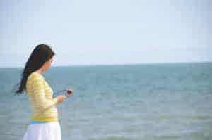 Woman Holding iPad by Sea