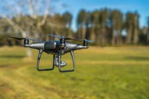 Grey Drone Flying Over Field