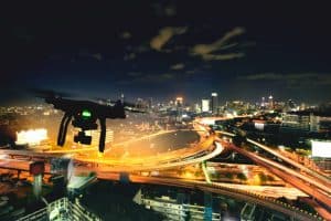 Drone Flying Above City at Night