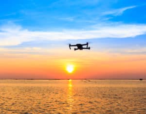 Drone flying over the sea and sunset