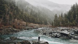 Man Standing Next to Lake