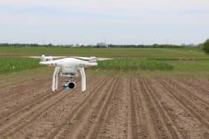 White Drone Flying Over Farmland