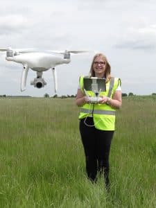 Woman Flying Drone in Field