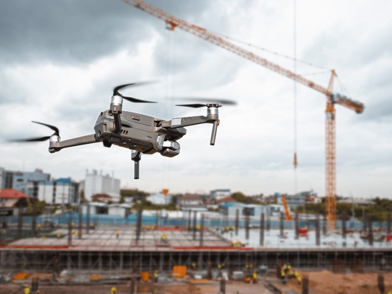 Drone being used on a construction site with a crane in the background