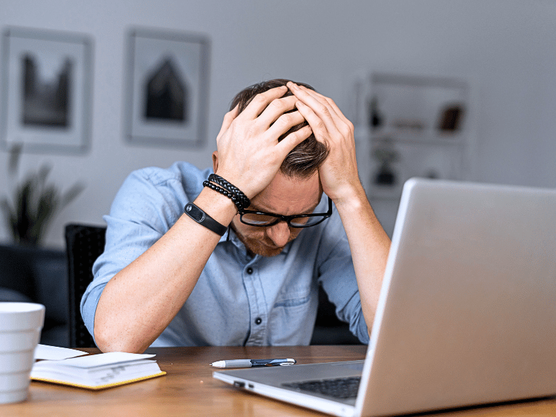 A man who has made a mistake in front of a laptop