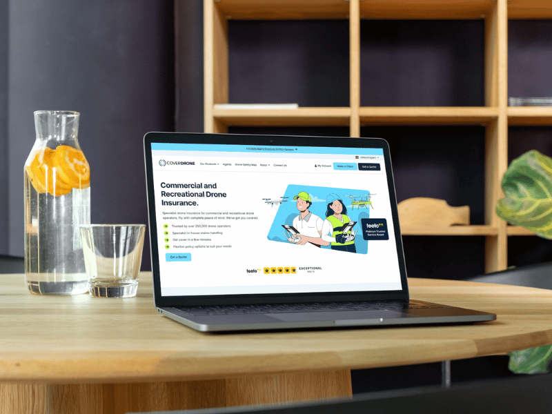 Table with a laptop showing the Coverdrone drone insurance website