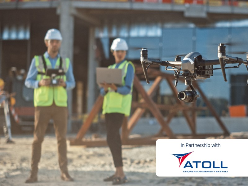 Commercial drone being operated at a construction site with pilots in safety gear, highlighting lawful flying and structured compliance in partnership with Atoll Drone Management System.