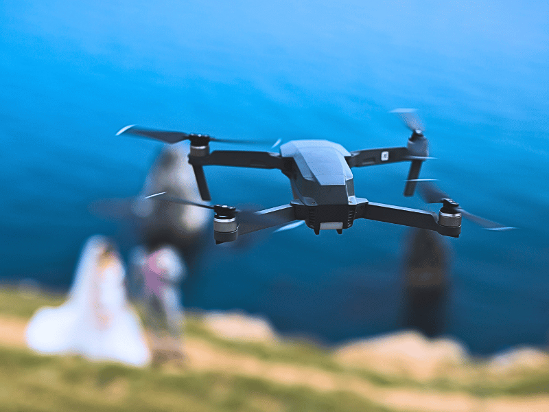 Drone photography insurance example showing wedding drone photography of a newlywed couple near the sea