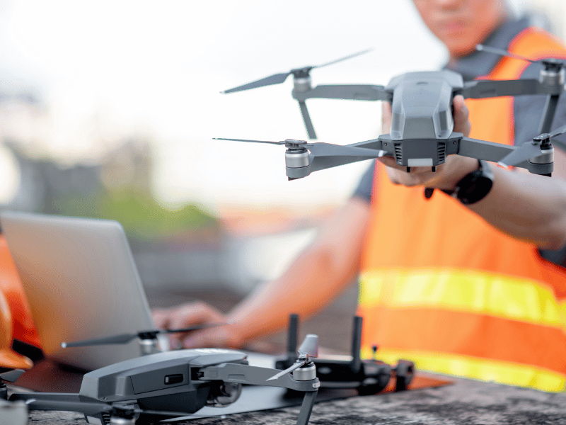 Commercial drone operator preparing equipment for construction site work
