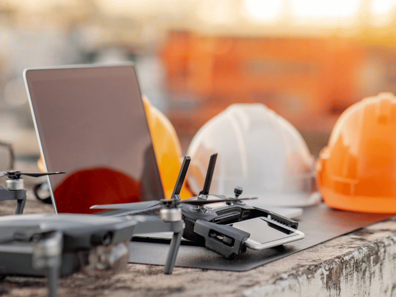 Drone equipment, laptop and safety helmets on a construction site