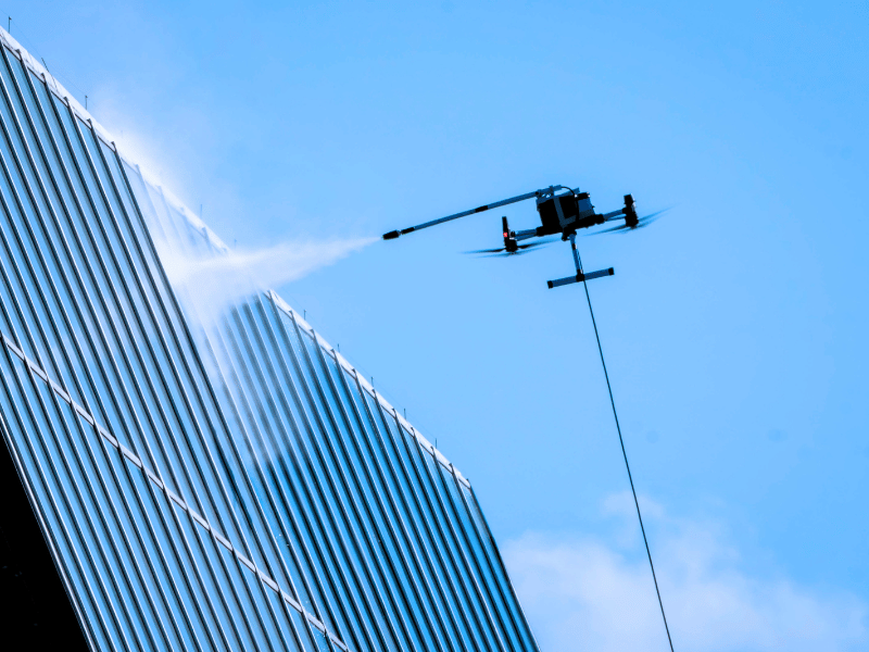 Drone power-washing an office building
