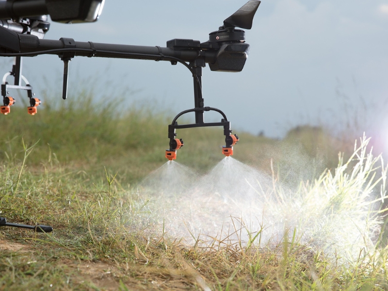 A farm drone spraying crops in a field